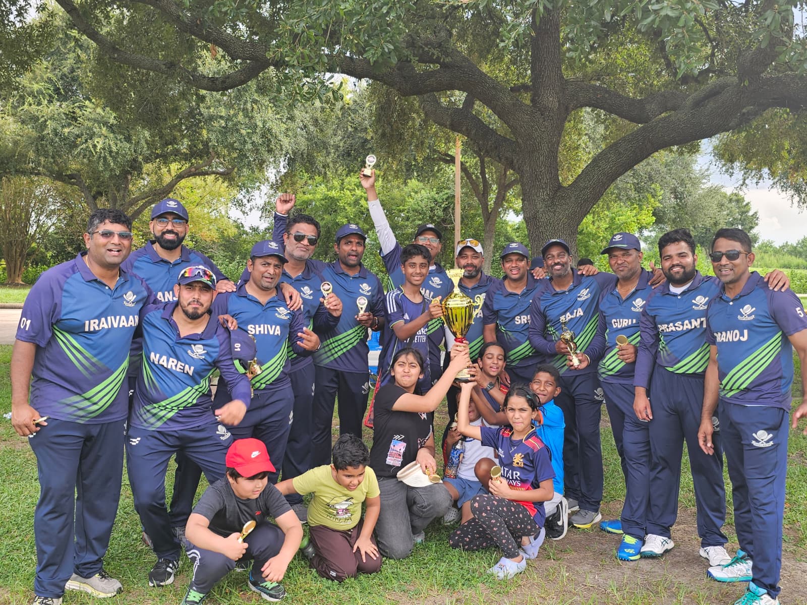 The Doesn't Matter squad celebrating with the championship trophy under the oak tree